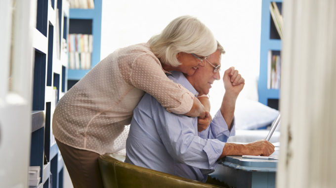 Image Of A Senior Husband And Wife Looking Over Bills.
