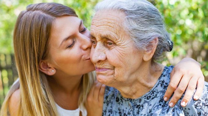 An Elderly Woman Being Embraced
