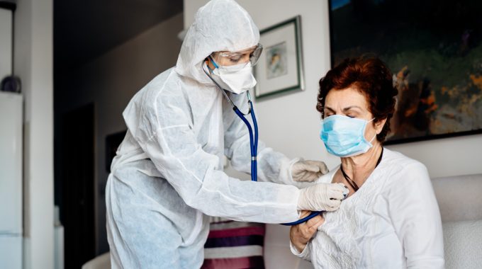 Hospice Nurse Treating A Patient With COVID-19