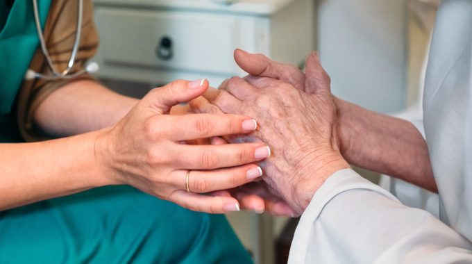 Nurse Holding Hands With A Hospice Patient.