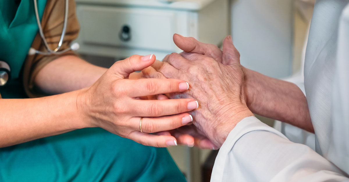 Nurse Holding Hands With A Hospice Patient.