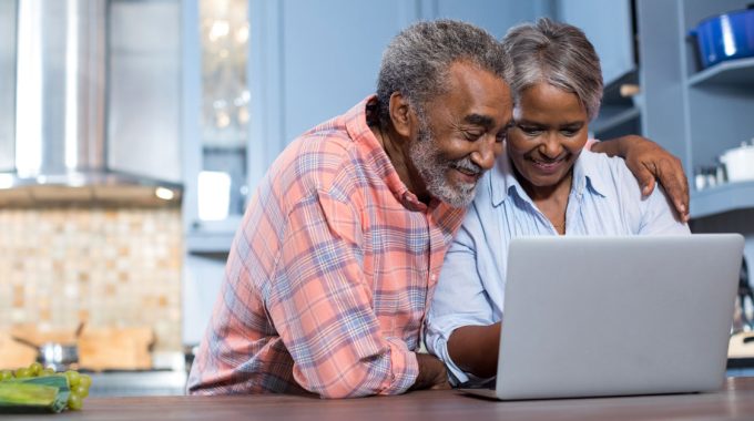 Senior African America Couple Researching Information On A Laptop.