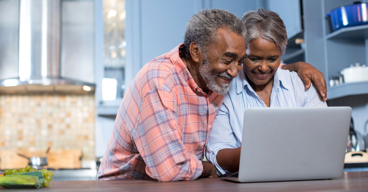 Senior African America Couple Researching Information On A Laptop.